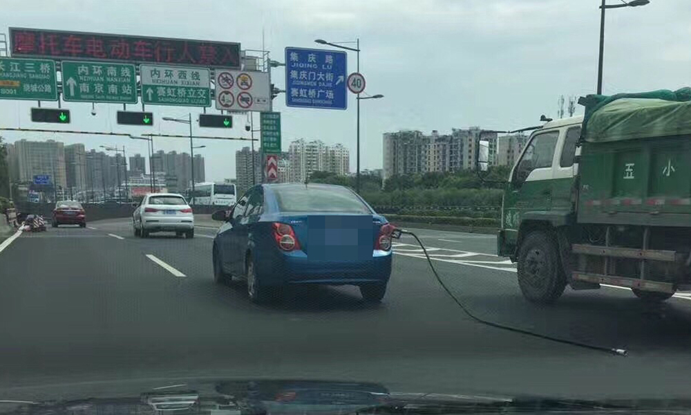 轿车车尾拖着油枪上路狂奔.jpg