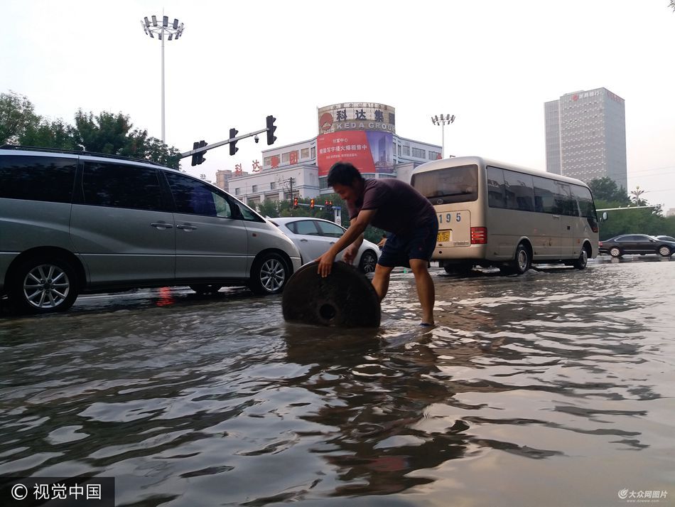井盖哥涉水搬井盖为防行人陷入