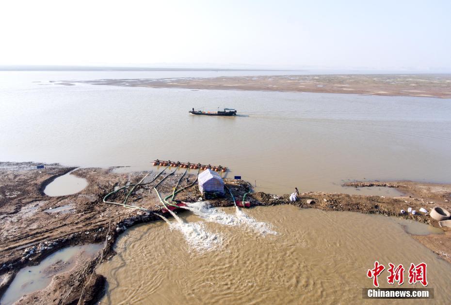 在鄱阳湖都昌印山附近水域,渔民在干涸的湖汊中捕鱼虾.