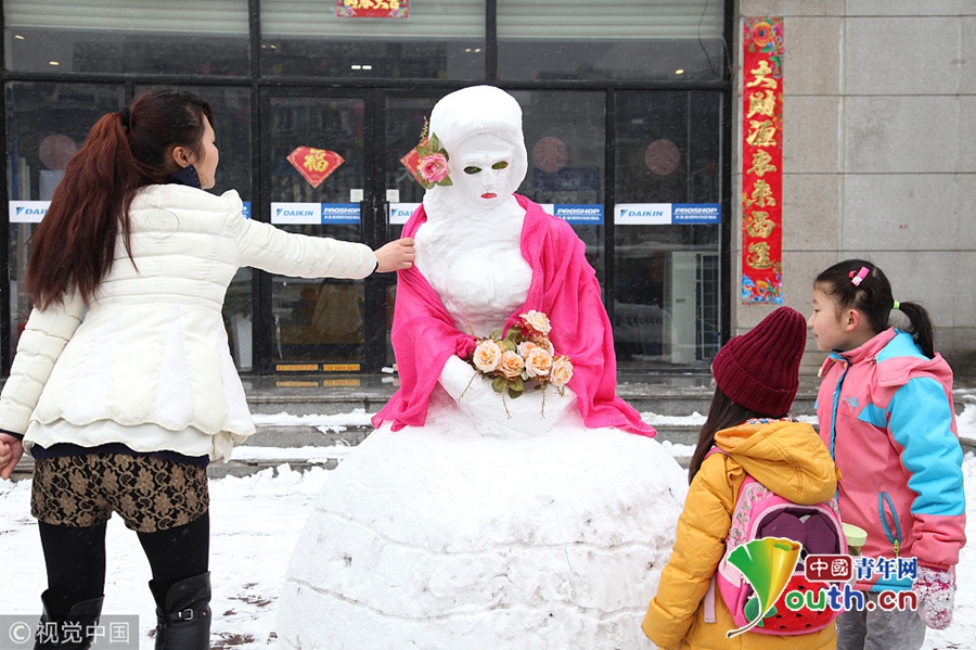 2016年1月31日,西西安现雪人"性感新娘",吸引路人合影.