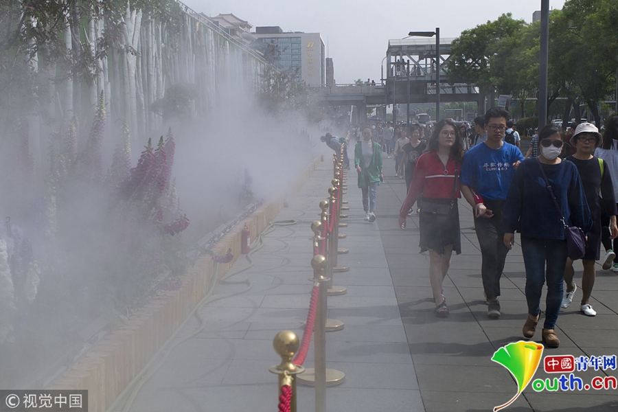 北京天气晴热 西单路边花坛开启喷雾设备