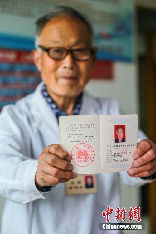 田起业展示他的《执业医师资格证》.陶维明 摄
