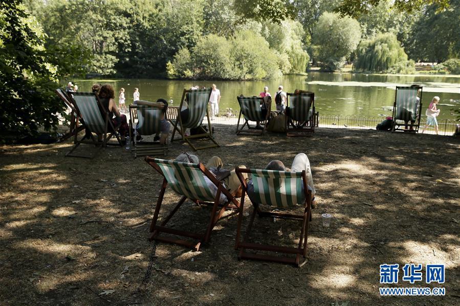 8月3日,在英国伦敦圣詹姆斯公园,人们在树荫下乘凉.