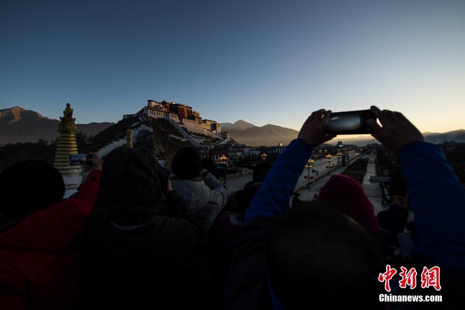 游客们在西藏拉萨药王山观景台拍摄布达拉宫日出,迎接2019年新年的到