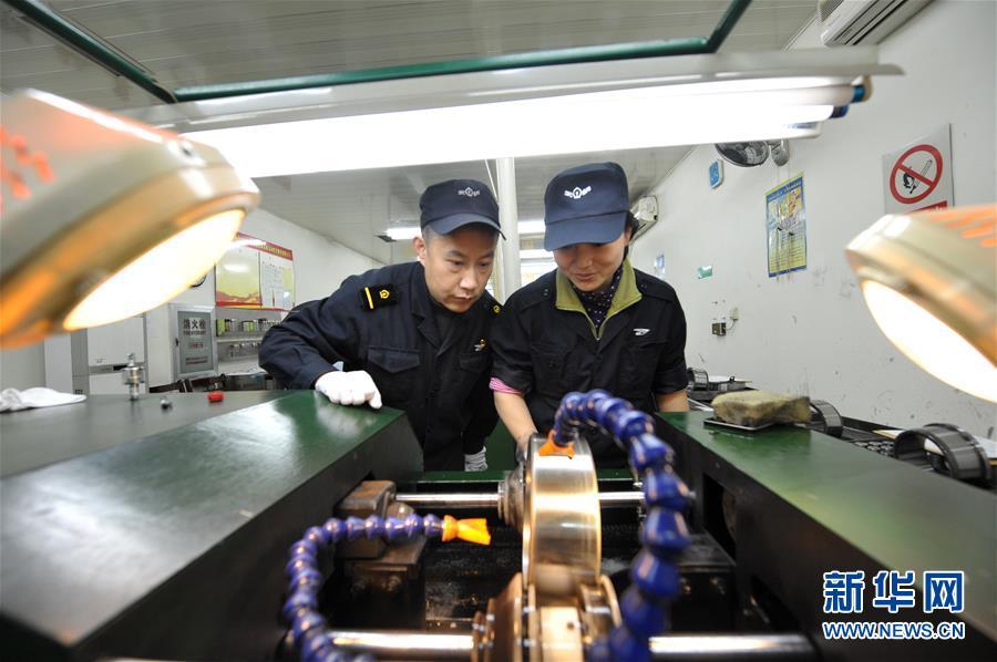 1月22日,质检员汪召坤(左)对火车车轮轴承进行检修.