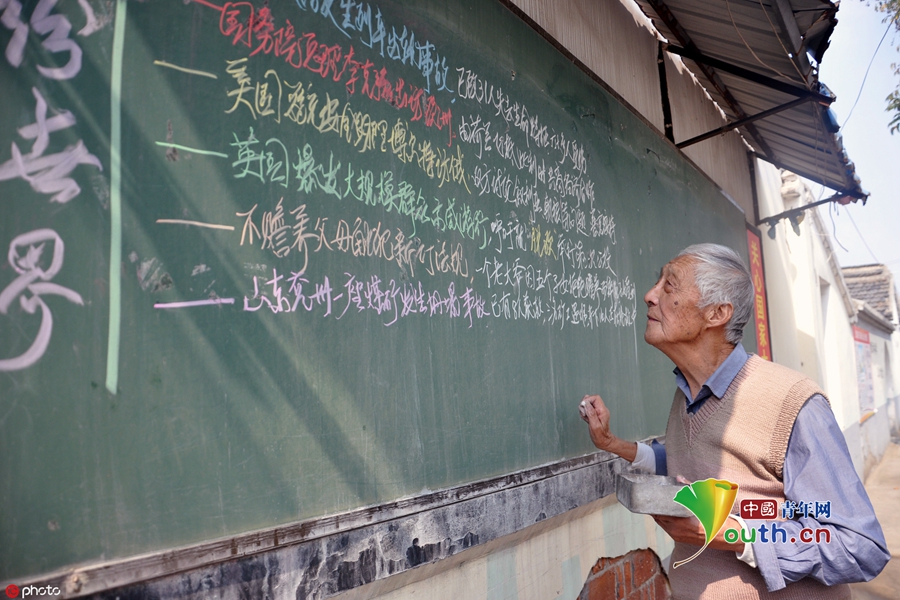 叶连平老师在写黑板报.图片署名: 签约摄影师/ic photo