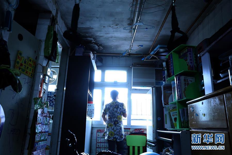 家住香港彩虹邨公屋的王女士站在狭小的房间内(9月17日摄).