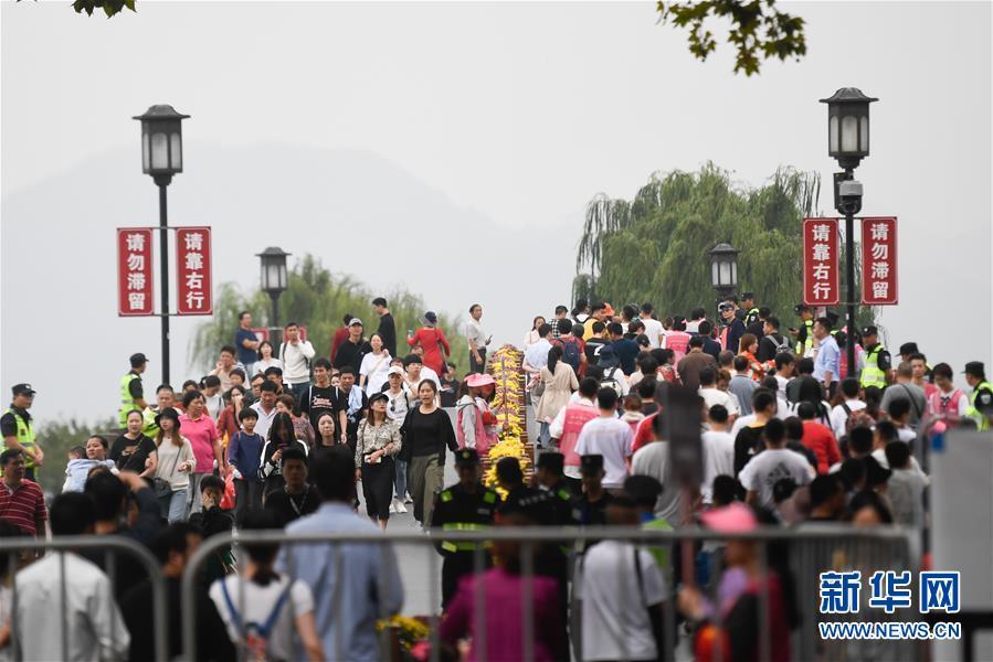 10月7日,杭州西湖风景区的断桥上游人络绎不绝。 经文化和旅游部综合测算,2019年国庆七天全国共接待国内游客7.82亿人次,同比增长7.81%;实现国内旅游收入6497.1亿元,同比增长8.47%。 新华社记者 黄宗治 摄