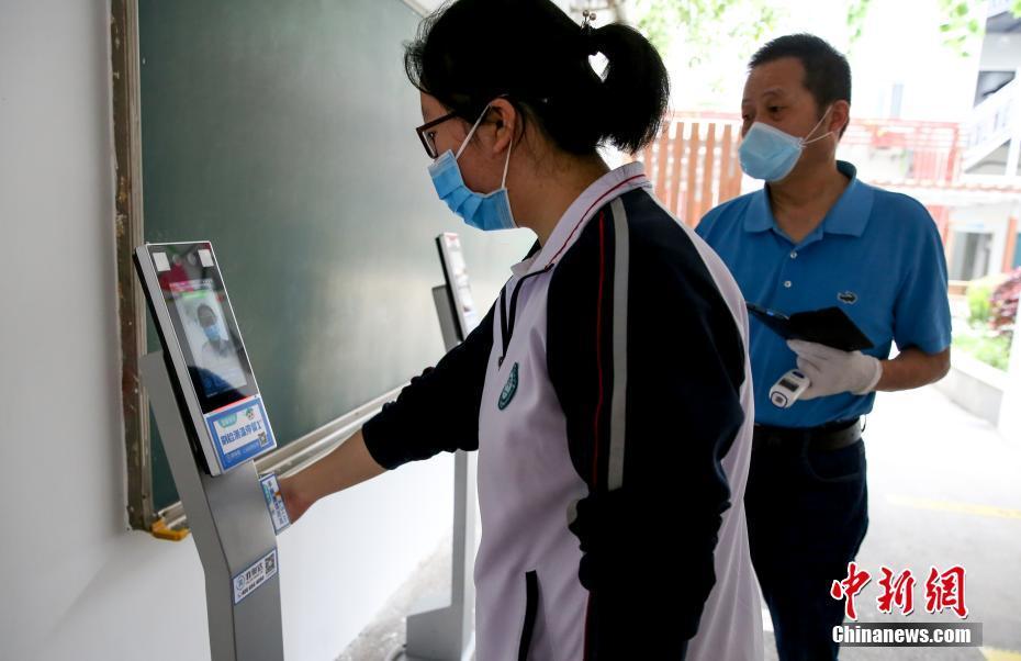 学生进入校区时进行手腕测温.中新社记者 张畅 摄