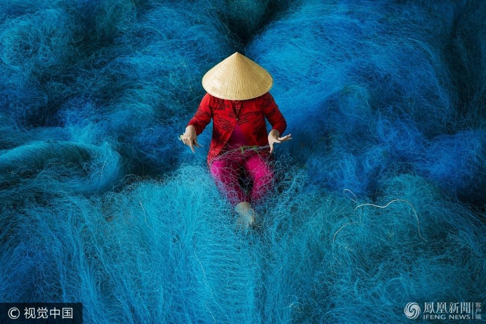 越南女工编织渔网 如置身蓝色海洋