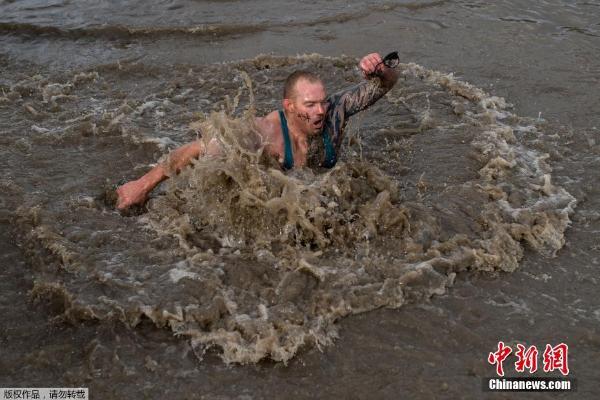 英国举行"硬汉"挑战赛 选手穿越浓烟泥浆中打滚