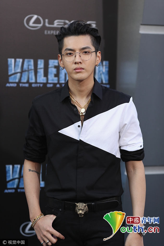 吴亦凡戴金丝边眼镜,身穿黑白拼色衬衫,下穿黑色紧身铅笔裤,系gucci