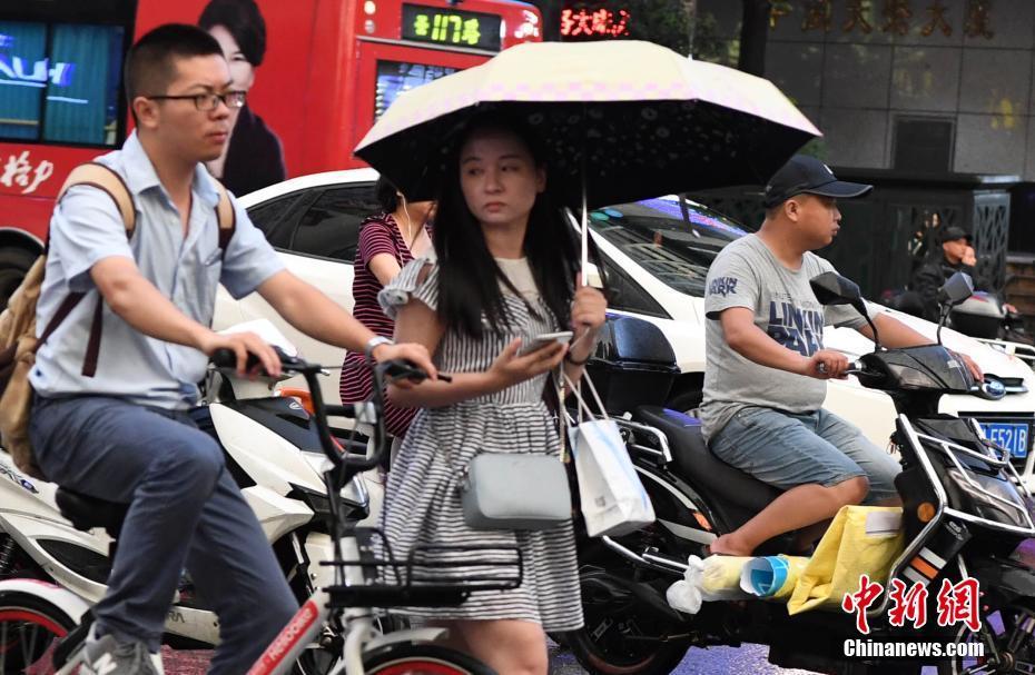 8月16日下午,福建福州突降雷阵雨,市民打伞出行.中新社记者 刘可耕 摄