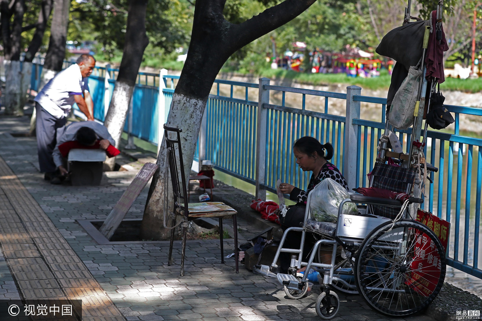 盲人推残疾妻子街边按摩擦鞋 每天吃两顿饭