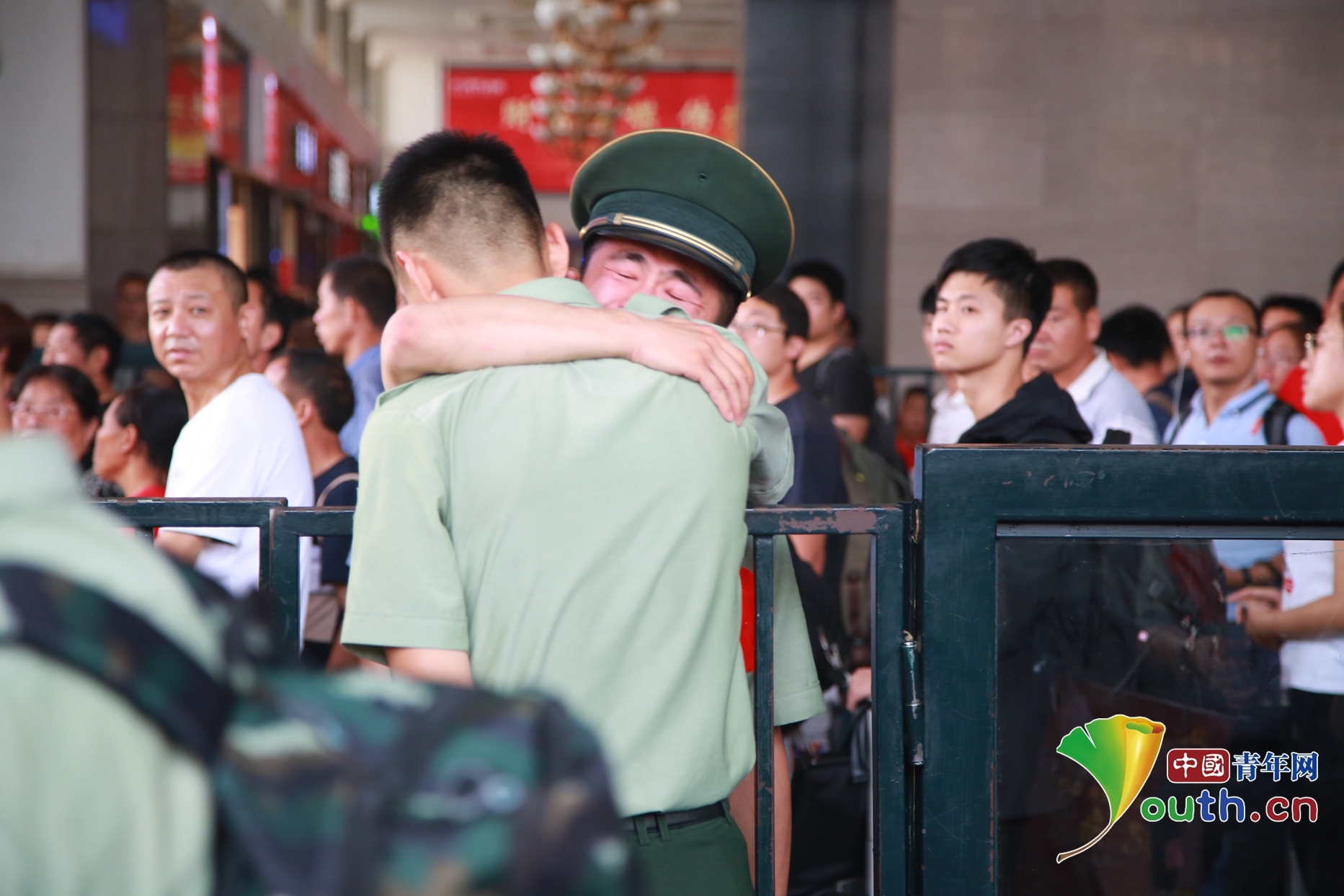 临别前,一位前来送站的战士抱住自己即将离开的战友痛哭.