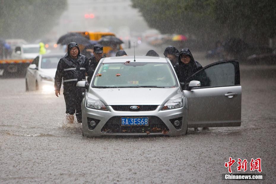 南京连夜暴雨致部分道路被淹 民众涉水而行
