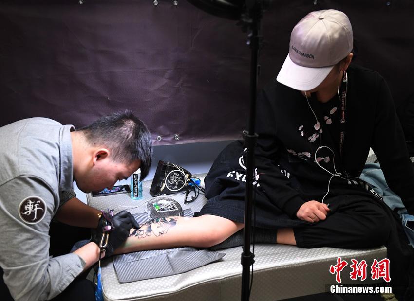 一位刺青师在现场进行刺青.张瑶 摄