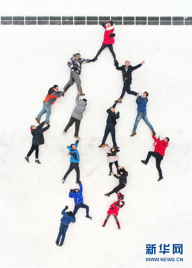 1月29日,湖南省桂阳县的摄影爱好者们在雪地摆造型,拍摄创意照片