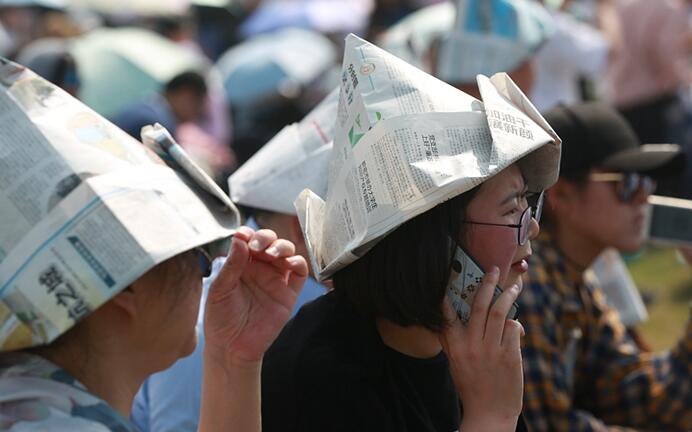 2018年4月27日,郑州航展举行,当天骄阳似火,市民用报纸自制成遮阳帽看