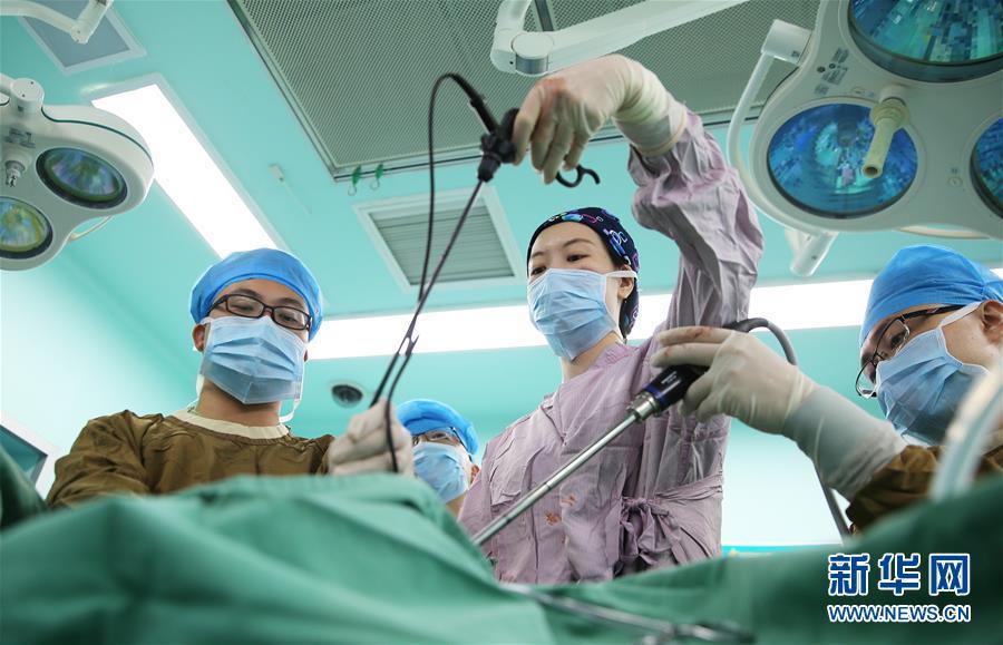 8月15日上午,谢娟娟(右二)在给患者做手术. 新华社发(曹正平 摄)
