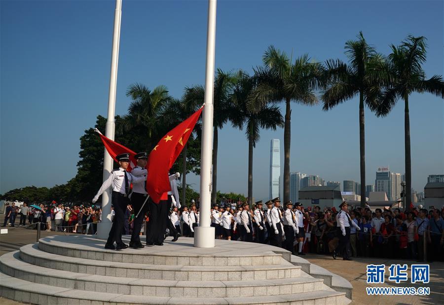 特写:永远盛开的紫荆花旁国旗飘扬