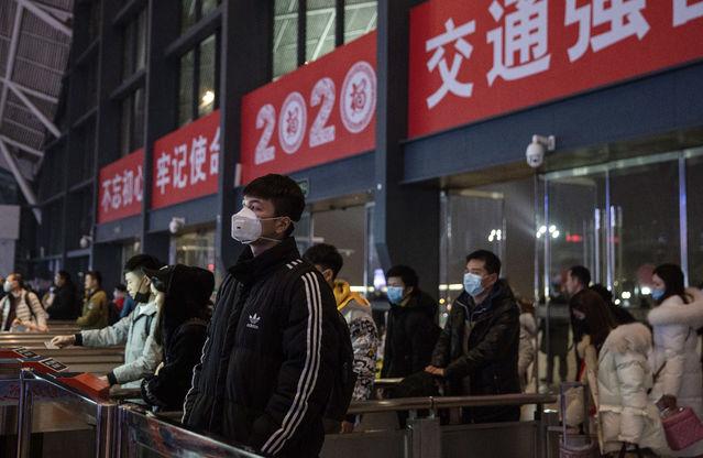 1月21日,湖北武汉火车站,戴口罩的旅客准备检票进站.