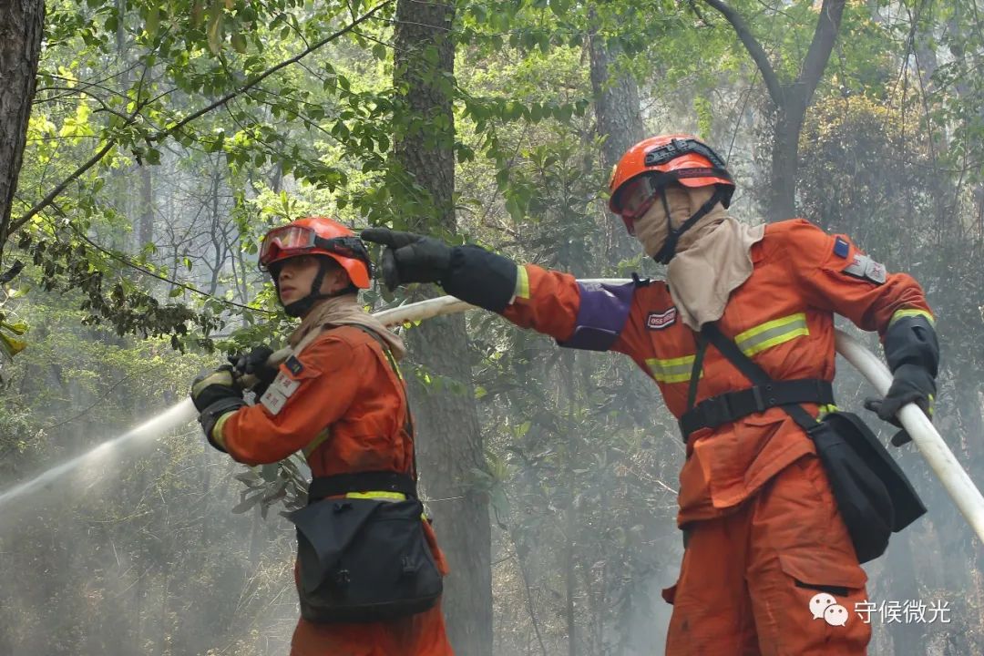 4月1日中午,两名消防指战员正在扑灭泸山卧云山起火点上的余火.