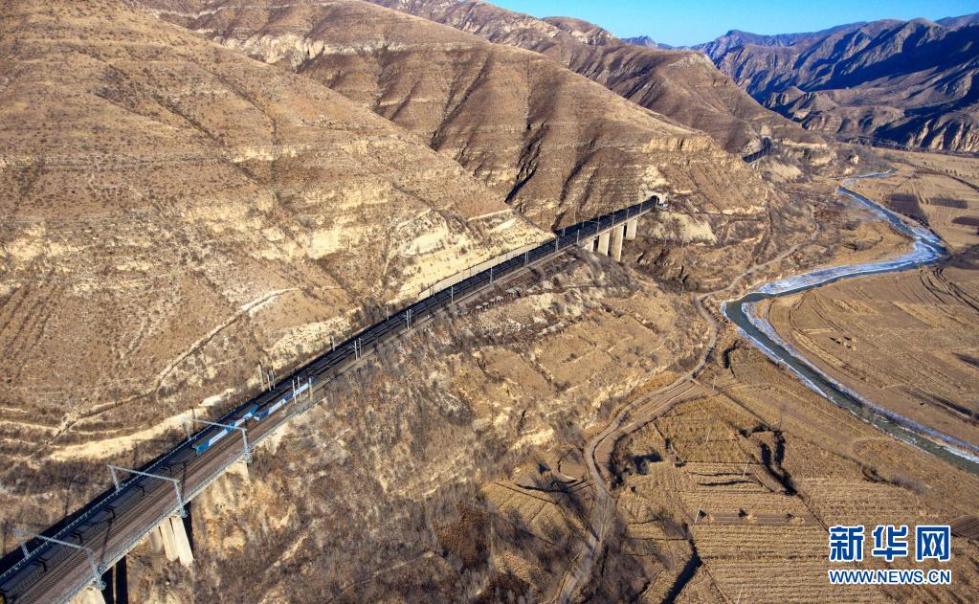 重载列车行驶在桑干河旁的大秦铁路上(2018年12月6日摄,无人机照片).