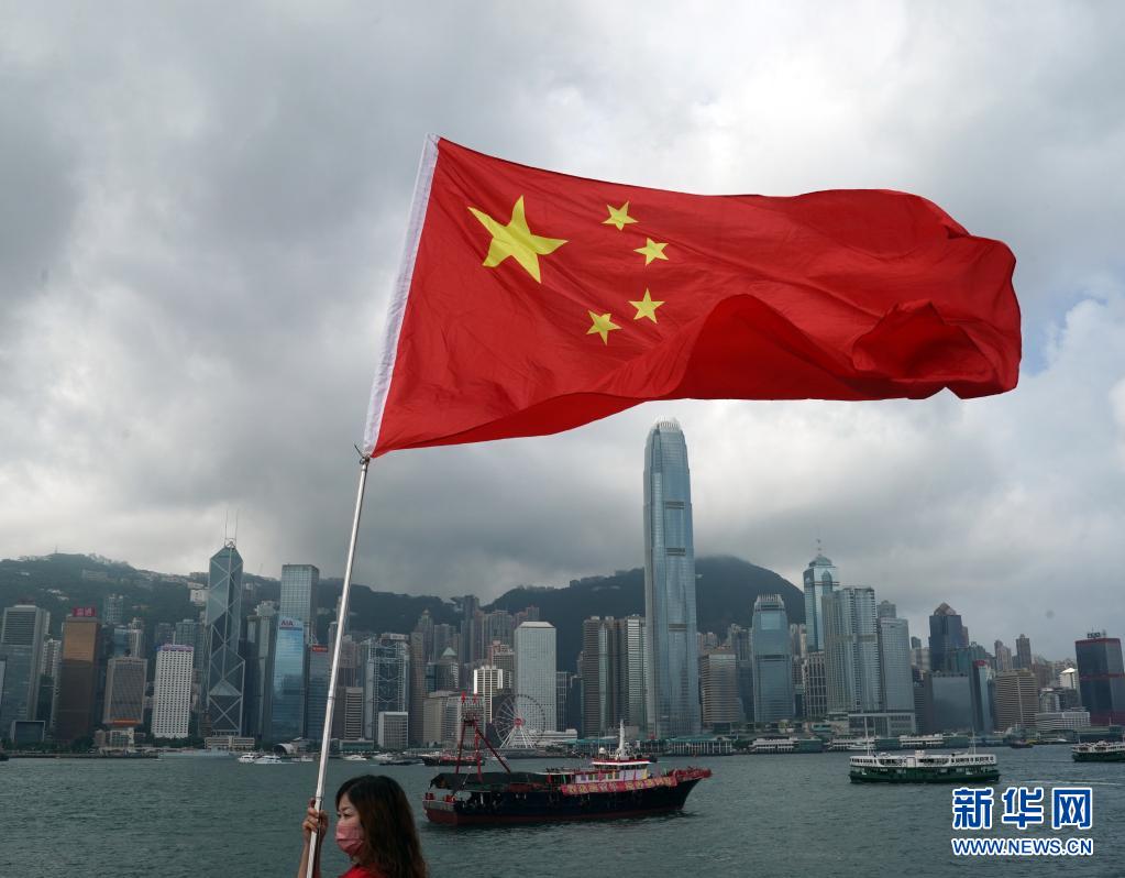 7月1日,在香港尖沙咀,香港市民挥舞国旗庆祝.新华社记者 李钢 摄