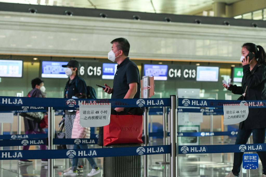 在哈尔滨太平国际机场,几名旅客准备进入安检通道(9月23日摄).