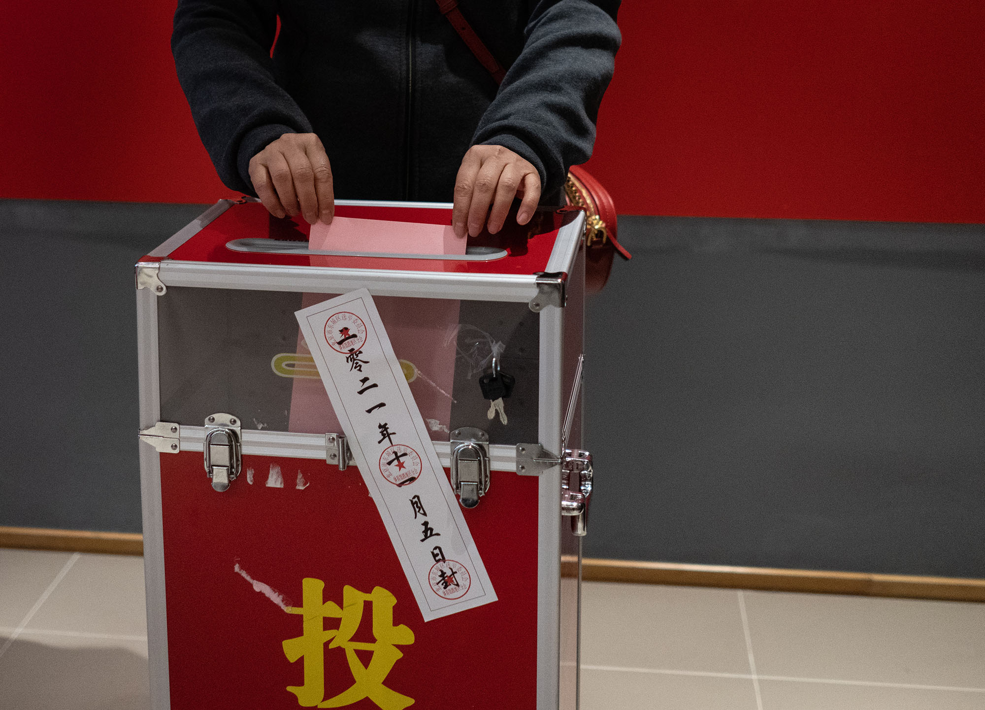 11月5日早晨,北京市东城区,一位选民用双手将选票投入票箱.