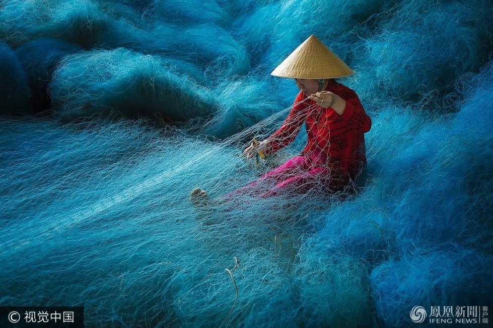越南女工编织渔网 如置身蓝色海洋