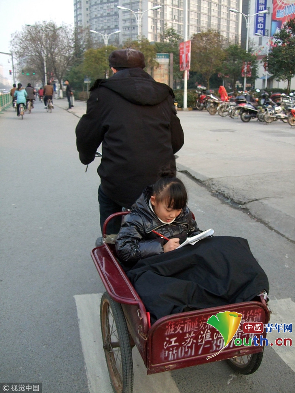 2010年2月23日傍晚,江蘇淮安街頭,一老人騎三輪車接孫女放學回家